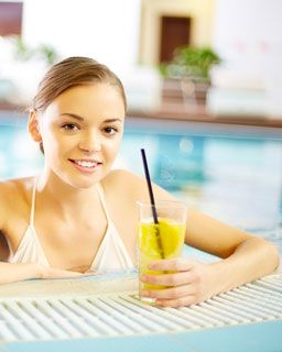 Lady at the pool drinking a glass of Summer's Lemonade